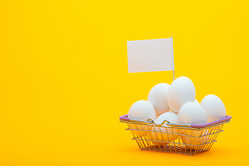 Image showing Metal grocery basket with eggs, a price tag is stuck