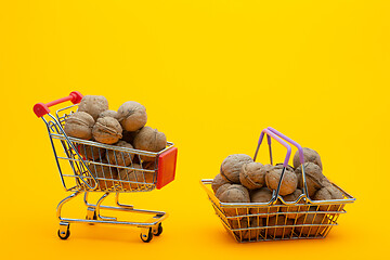 Image showing Walnuts are in the grocery basket and trolley, bright orange background