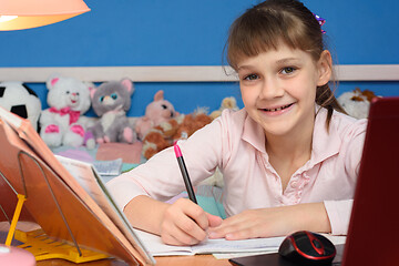 Image showing Portrait of a cheerful student doing homework at home