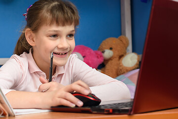 Image showing Happy girl at home performs online homework