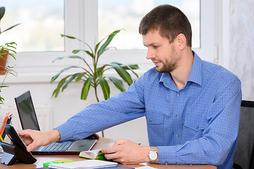 Image showing Office employee picks up the a phone