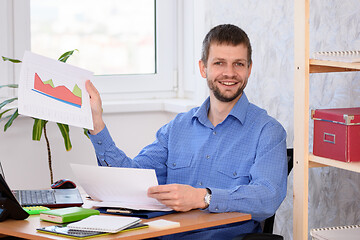 Image showing Office employee joyfully showing a document with charts