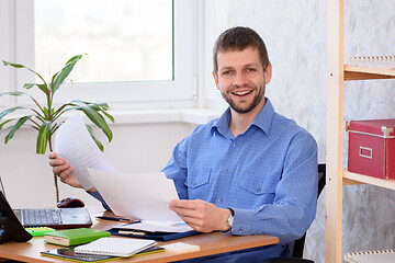 Image showing Successful businessman joyfully looks at the paper and looked into the frame