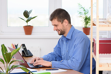 Image showing Successful businessman works in the computer at the office