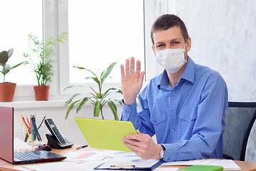 Image showing Portrait of an office worker in a medical mask working remotely