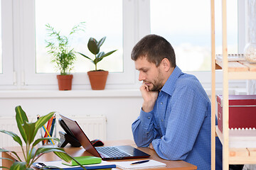 Image showing A typical weekday office specialist working on a computer while sitting at a desk