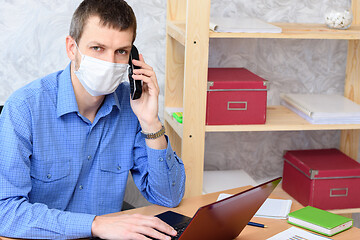 Image showing Office specialist in a medical mask works at a computer in the office