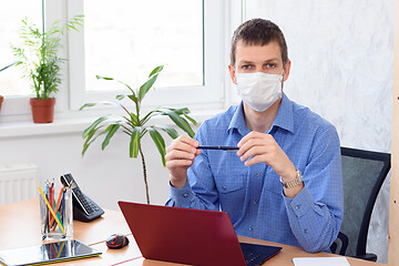 Image showing Portrait of a businessman with a medical mask on his face in an office in quarantine