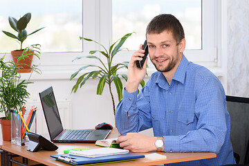 Image showing Confident office specialist talking on the phone and looked into the frame