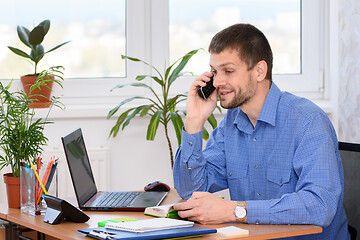 Image showing A man in the office talking on the phone