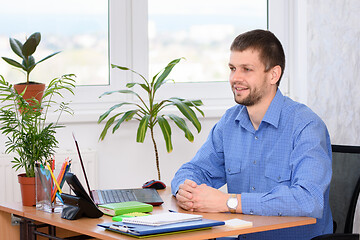 Image showing The office employee at the workplace receives the client