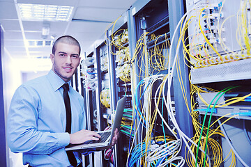 Image showing businessman with laptop in network server room