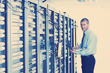 Image showing businessman with laptop in network server room