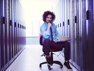 Image showing engineer working on a laptop in server room