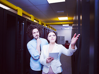 Image showing engineer showing working data center server room to female chief