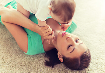 Image showing happy mother playing with little baby at home