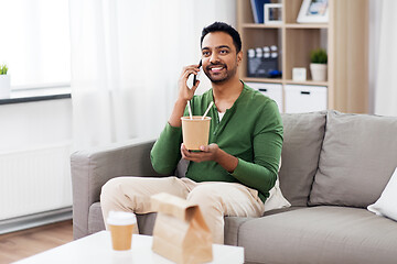 Image showing smiling indian man eating takeaway food at home