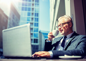 Image showing senior businessman with laptop drinking coffee