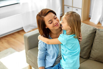 Image showing little daughter hugging her mother at home