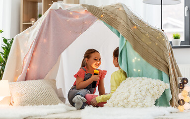 Image showing girls playing with torch in kids tent at home