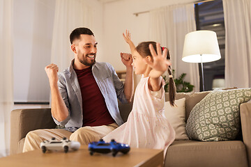 Image showing father and daughter playing video game at home