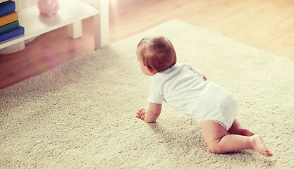 Image showing little baby in diaper crawling on floor at home