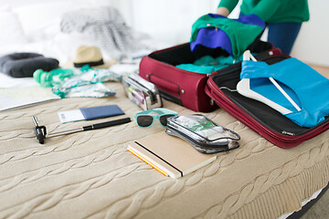 Image showing woman packing travel bag at home or hotel room