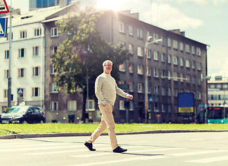 Image showing senior man walking along city crosswalk