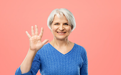 Image showing smiling senior woman showing palm or five fingers