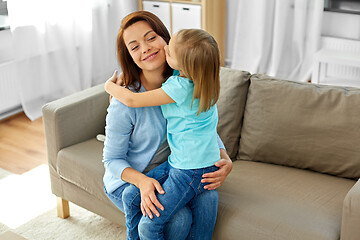 Image showing daughter hugging and kissing her mother at home