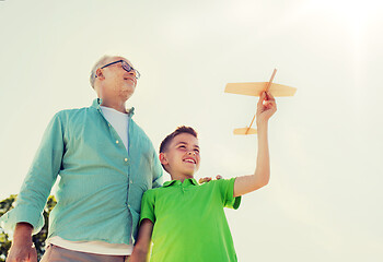 Image showing senior man and boy with toy airplane over sky