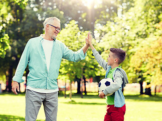 Image showing old man and boy with soccer ball making high five
