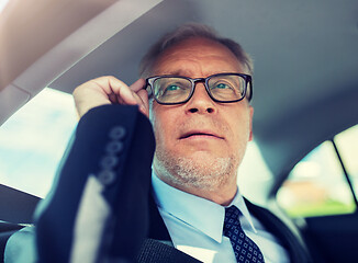 Image showing senior businessman calling on smartphone in car