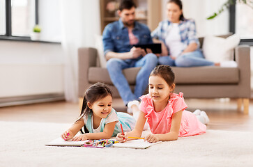 Image showing happy sisters drawing in sketchbooks at home