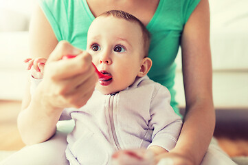 Image showing mother with spoon feeding little baby at home