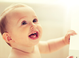 Image showing happy little baby boy or girl at home looking up