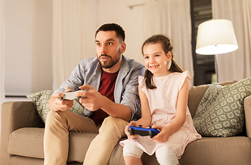 Image showing father and daughter playing video game at home