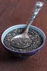 Image showing Chia seeds with spoon in the bowl on the wooden background