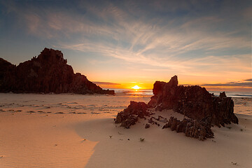 Image showing Golden sunrise warm sunlight on the remote rocky beach