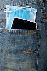 Image showing Facial mask and mobile phone in back pocket