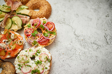 Image showing Homemade Bagel sandwiches with different toppings, salmon, cottage cheese, hummus, ham, radish