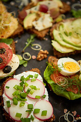 Image showing Assortment of home made sandwiches with various toppings. With colorful fresh vegetables