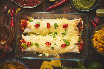 Image showing Vegetable Burritos served in glass heatproof dish. With salsa, guacamole, nachos and ingredients