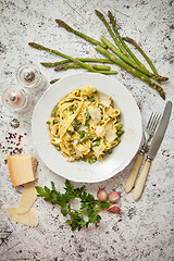 Image showing Homemade tagliatelle pasta with creamy ricotta cheese sauce and asparagus served white ceramic plate