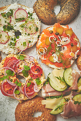 Image showing Homemade Bagel sandwiches with different toppings, salmon, cottage cheese, hummus, ham, radish