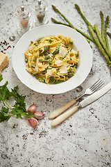 Image showing Tagliatelle pasta with creamy ricotta cheese sauce and asparagus served white ceramic plate