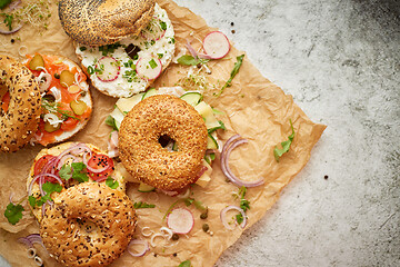 Image showing Tasty colorful various bagels with healthy ingredients served on brown baking paper