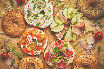 Image showing Tasty colorful various bagels with healthy ingredients served on brown baking paper