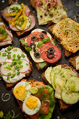 Image showing Top view of different decorated sandwiches as appetizer. Healthy food. Vegetable meal