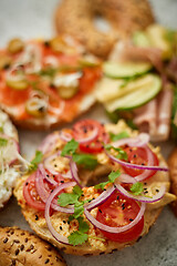 Image showing Assortment of different kinds toppings homemade bagels sandwiches with sesame and poppy seeds